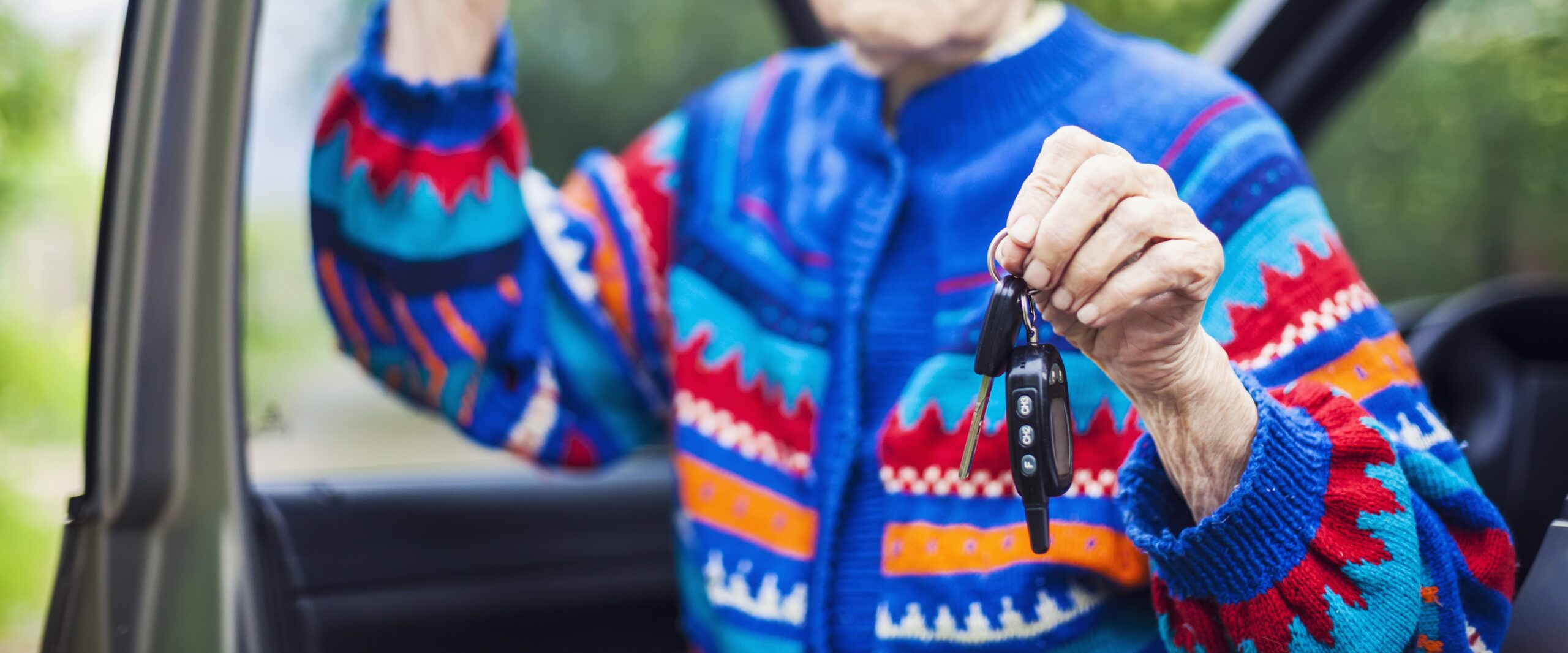 Senior woman holding car key and smiling