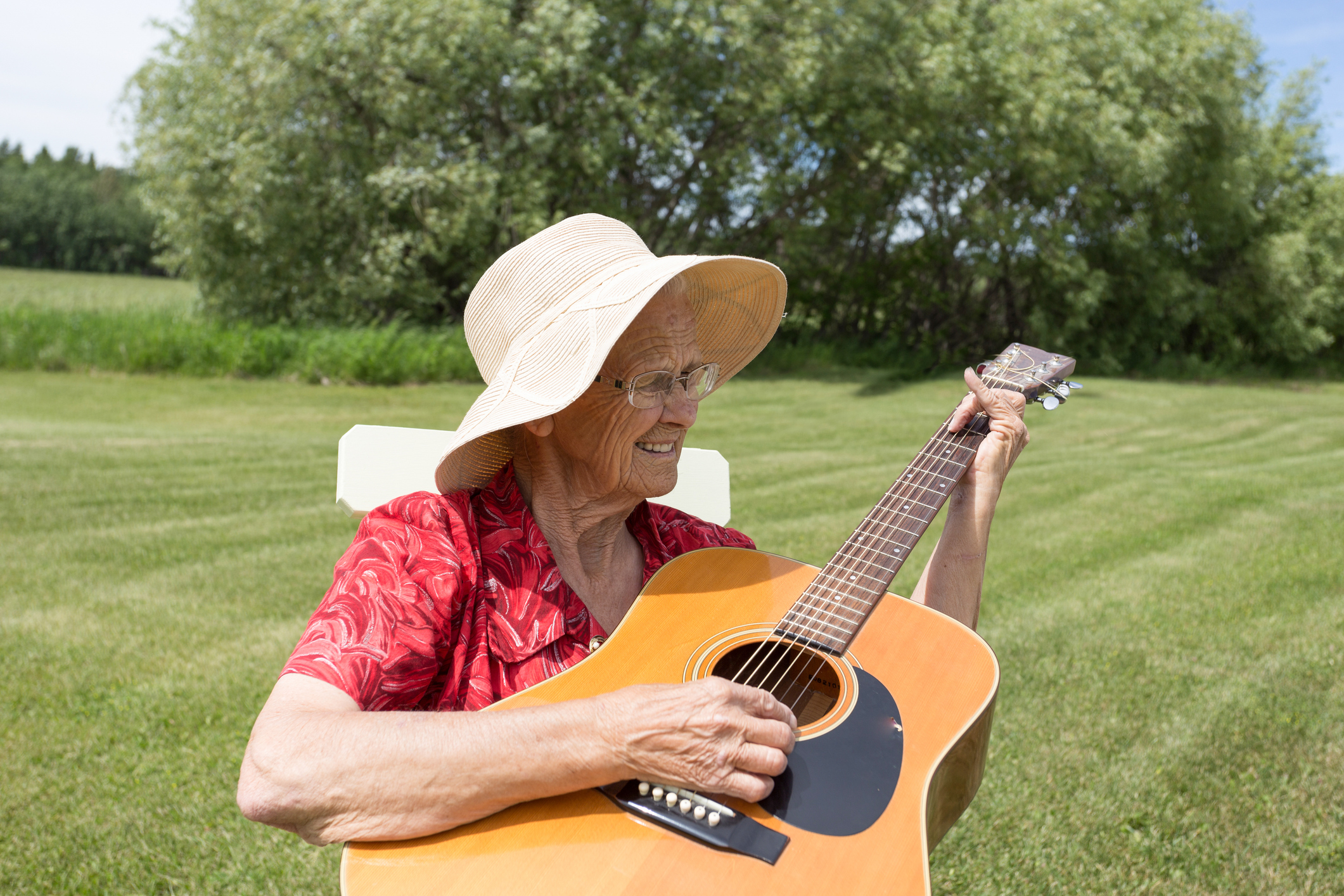 elderly woman playing guitar